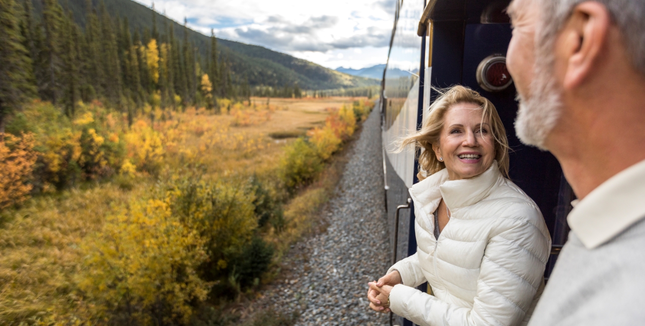 couple smiling on the GoldLeaf service platform on rocky mountaineer