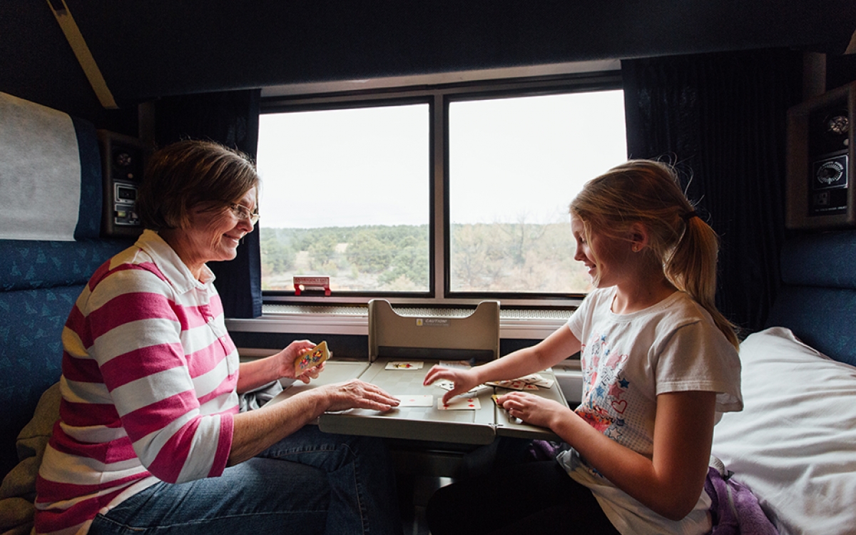 mother and daughter playing cards in their private room aboard Amtrak
