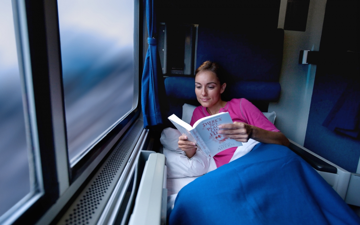 woman reading book in a roomette onboard amtrak