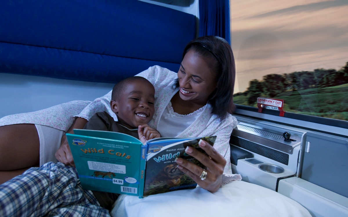 mom and child reading book in private room onboard amtrak