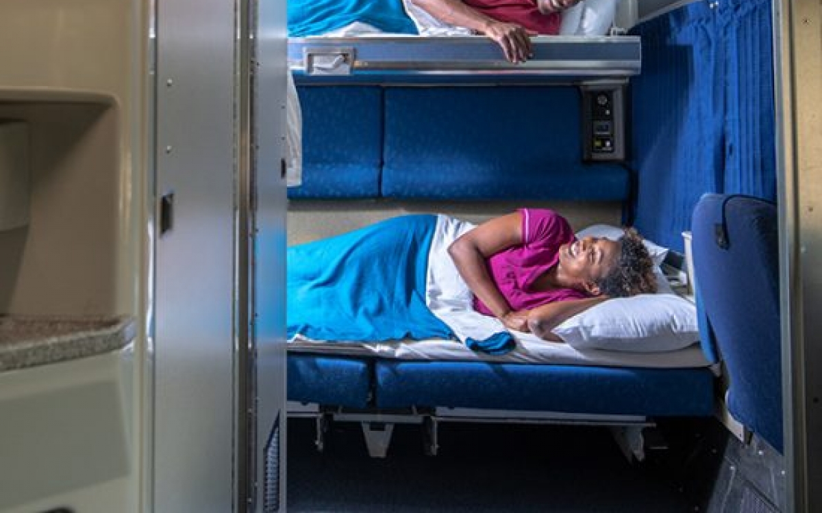 couple looking at each other from bunkbeds onboard amtrak