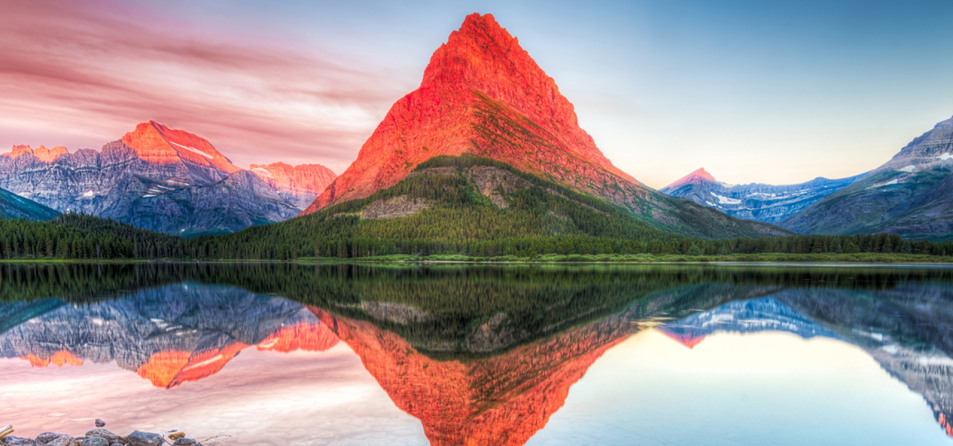 Destination-Glacier-National-Park Stunning reflections on Swiftcurrent Lake in northern Montana at sunrise
