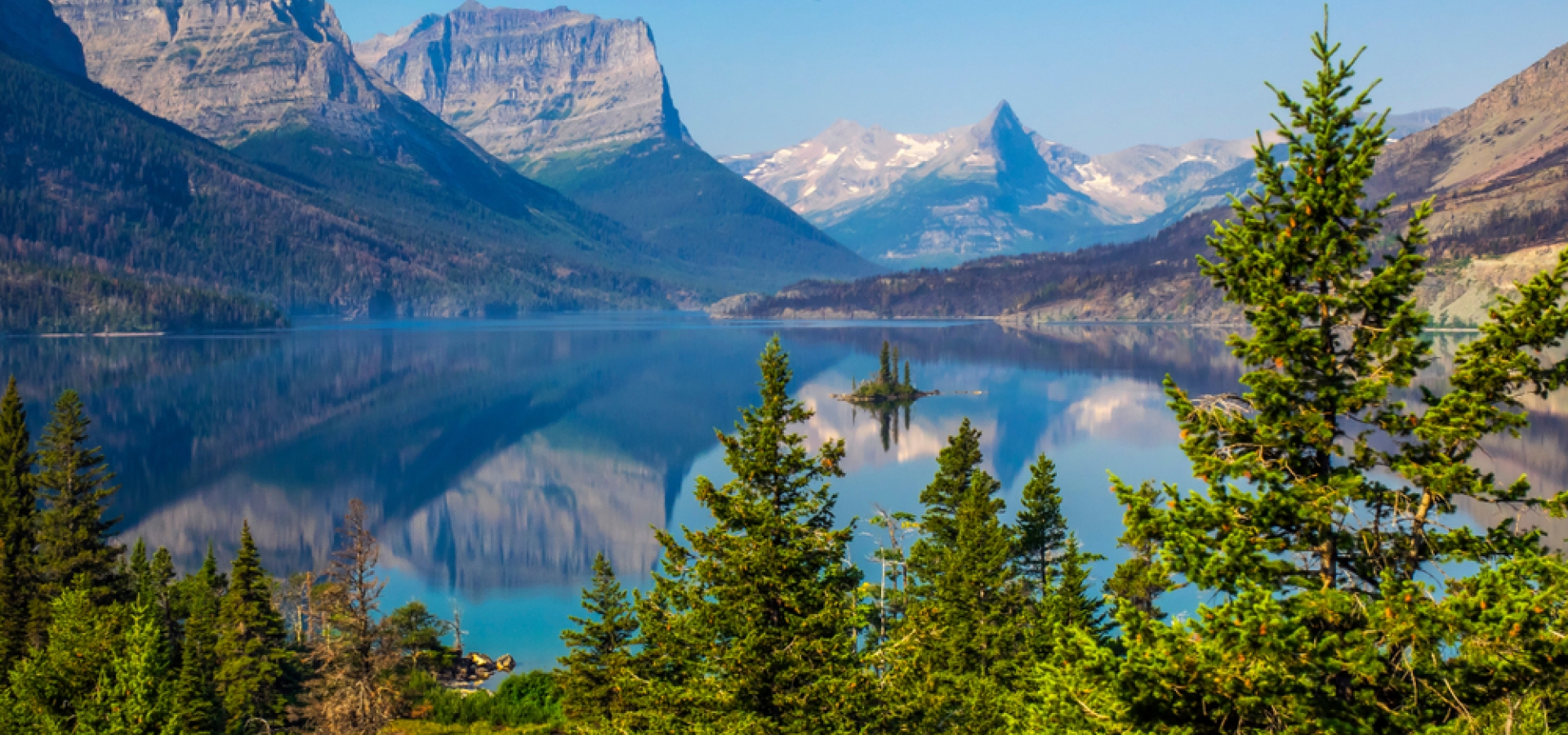 Goose Island in the middle of the St. Mary's lake with mountains peaks and reflection on background in Glacier National Park, Montana.